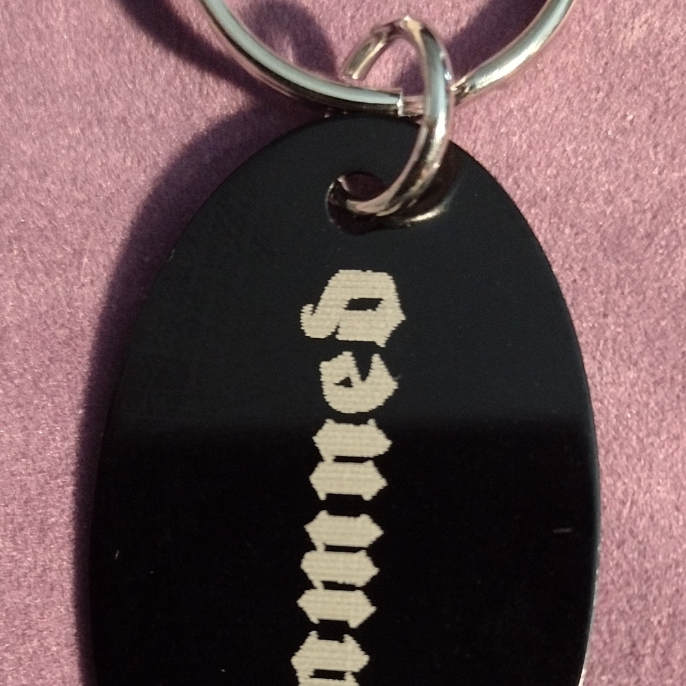 Black Oval Keychain with Silver Text